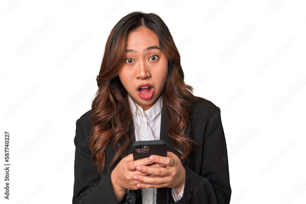 A young Chinese businesswoman looks surprised while glancing at her phone, perhaps receiving unexpected news or a message that has left her amazed. A young Chinese businesswoman looks surprised while glancing at her phone, perhaps receiving unexpected news or a message that has left her amazed.