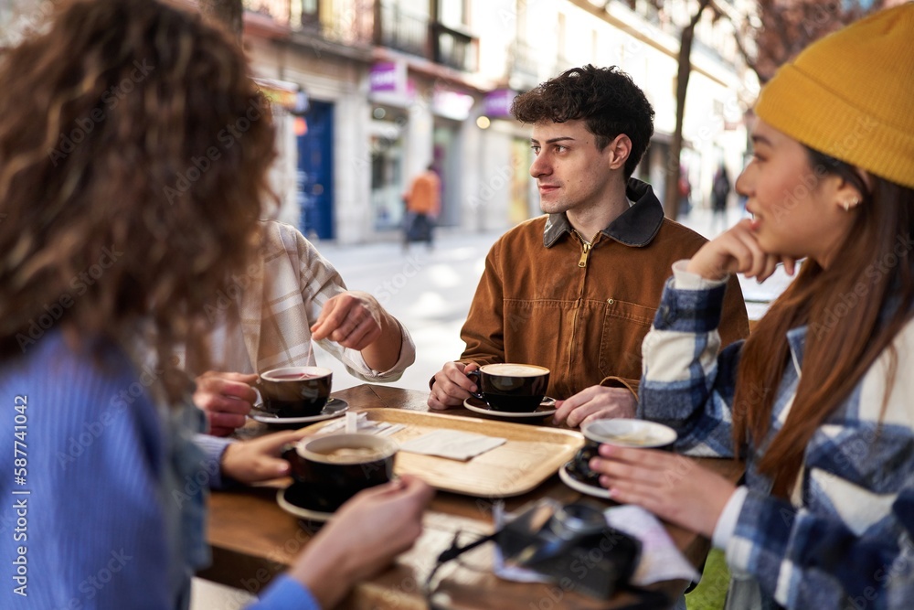 A multicultural group of friends enjoying coffee and tea after their vacation. A multicultural group of friends enjoying coffee and tea after their vacation.