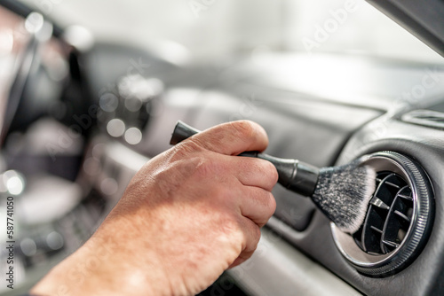 cleaning the interior of a luxury car with a brush