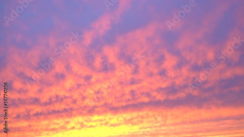 Beautiful evening blue sky at sunset with flaming bright light clouds. A warm summer evening at sunset. Bright sunset.