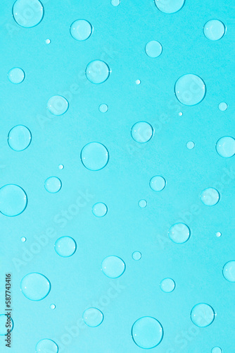 Bright pastel blue background with water and rain drops. Creative minimal concept of water and hydration.