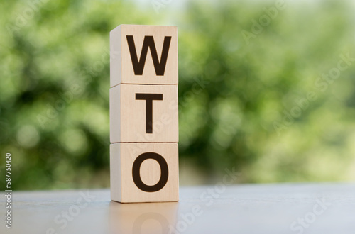 The letters WTO on the wooden cubes, nature background, business and finance concept. WTO - short for World Trade Organization