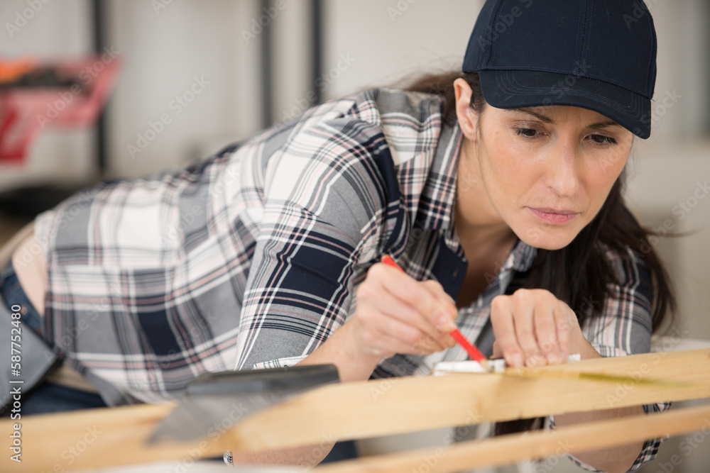 female carpenter marking position on wood female carpenter marking position on wood
