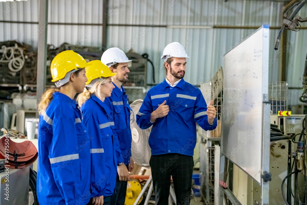 Engineer explaining to controlling robotic welding process to welder in factory. Engineer explaining to controlling robotic welding process to welder in factory.