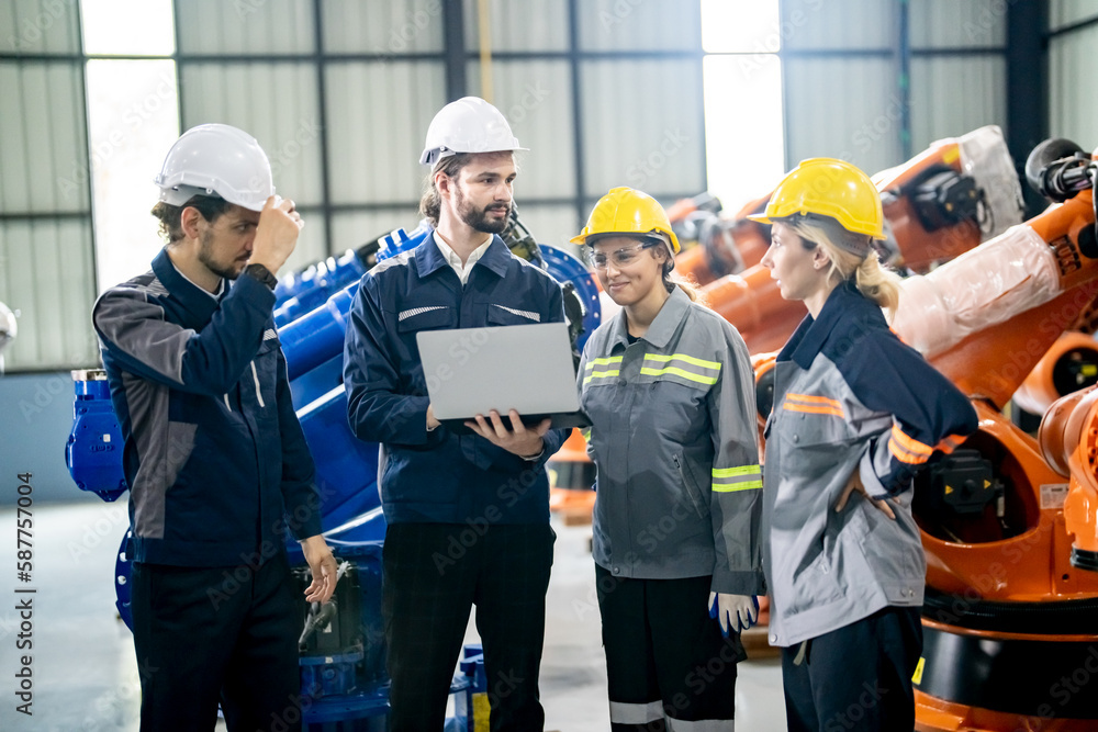 Engineer with robot in automotive parts factory Engineer with robot in automotive parts factory
