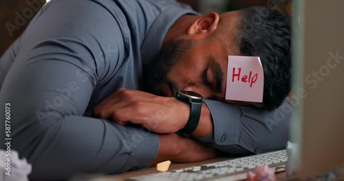 Man, night and sleeping at desk in office with fatigue, tired and rest with sticky note on head for help. Businessman, sleep and paper on forehead at table with burnout, mental health and overworked photo