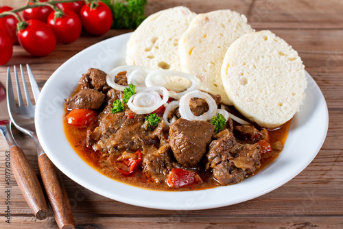 Traditional czech goulash with dumplings on table