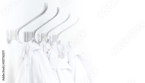 Close up of a row of white lab coats or doctors coats as a symbol for healthcare and science
