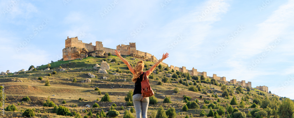 Fototapeta premium Tour tourism in Spain- Woman tourist looking at impressive castle in Castile and Leon- Gormaz, Soria province