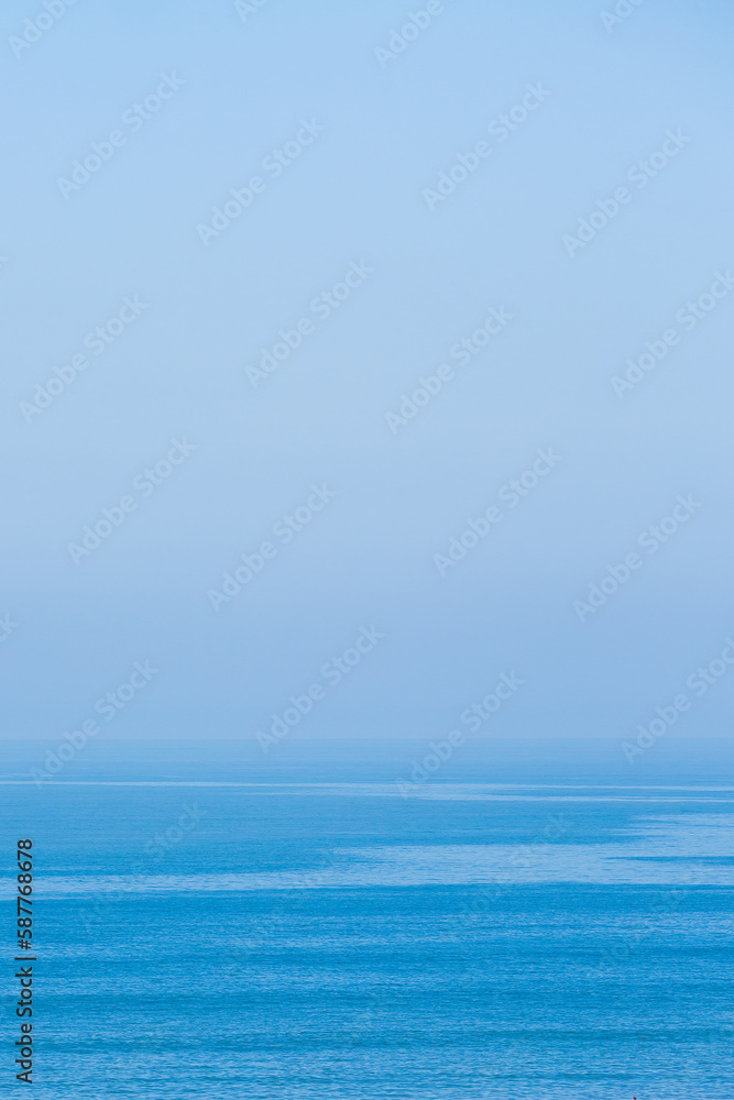 Photograph of the sea joining the sky on the horizon in a blue tone