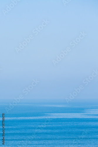 Photograph of the sea joining the sky on the horizon in a blue tone
