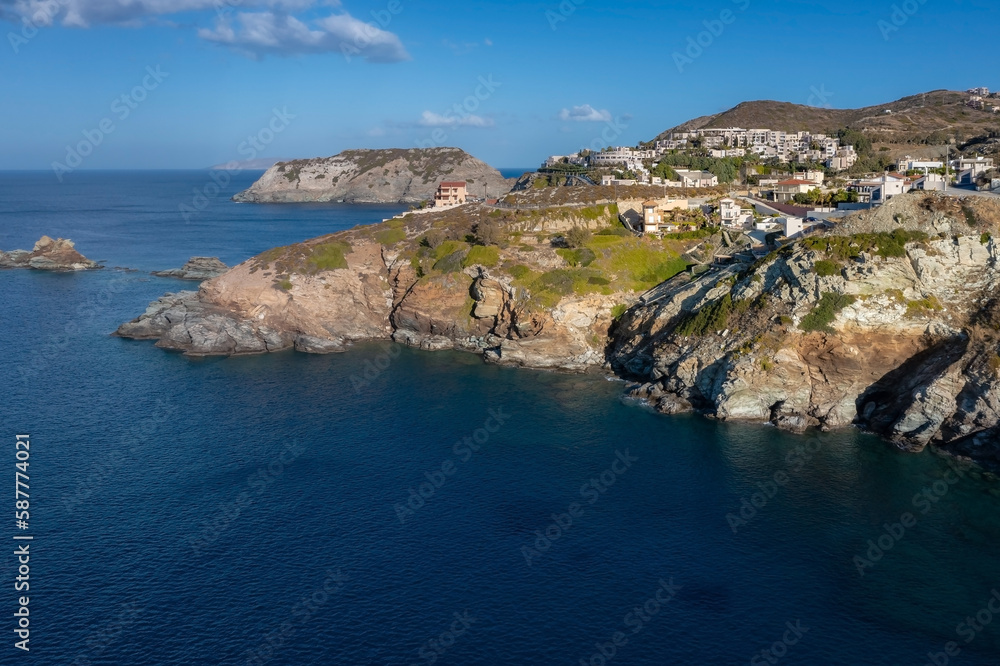 Indented rocky coastline with tourist hotels and guesthouses above crystal clear sea, Crete, Greece