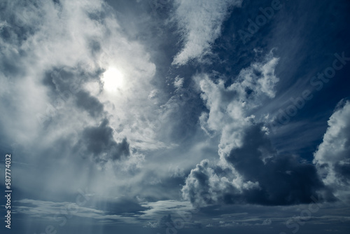 Dramatic cloudscape of various types of clouds with the sun brightly shining from behind the clouds