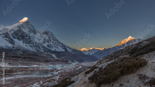 Mountain valley in Himalayas at dawn with sunlit tops of mountains, Ama Dablam, Chukhung, Nepal photo