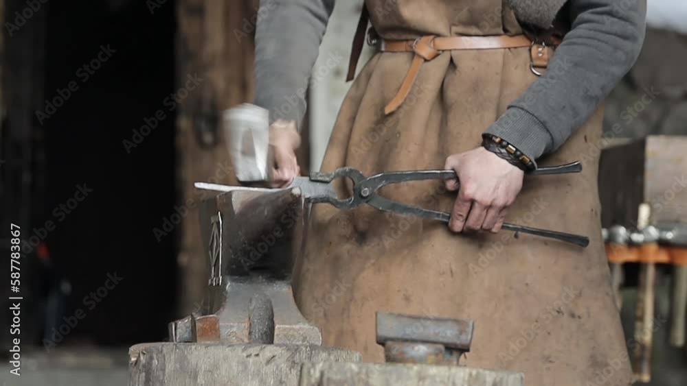 blacksmith forging a workpiece on an anvil with a hammer blacksmith forging a workpiece on an anvil with a hammer
