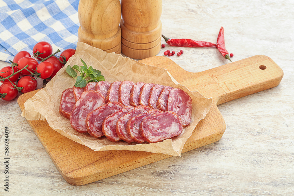 Sliced salami sausages over board