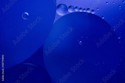 Water bubbles with oil drops in blue water.