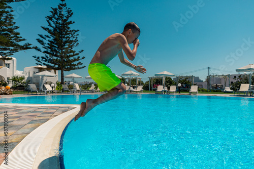Naxos, Grece - July 20, 2020 - Boy jumping to the pool in the small family hotel on Naxos Island © Piotr