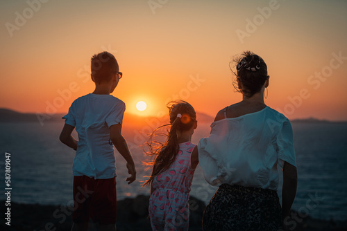Naxos, Grece - July 20, 2020 - Mother and children having amazing time watching amazing sunset over Naxos Island