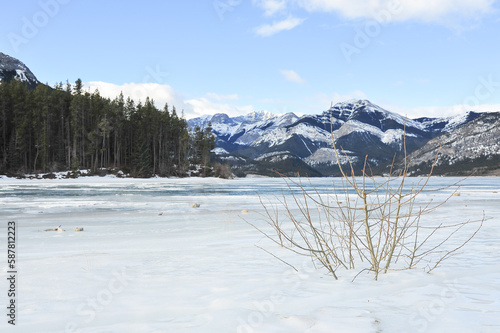 frozen ice covered lake by snow covered mountains, Kananaskis Country, Alberta, Canada