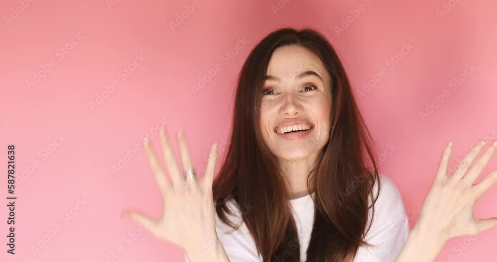 Happy girl smiling and holding hand while pointing finger trendy wedding ring isolated on pink background. She points at the engagement ring on her finger. Wow emotions. Marriage proposal. Happy girl smiling and holding hand while pointing finger trendy wedding ring isolated on pink background. She points at the engagement ring on her finger. Wow emotions. Marriage proposal.