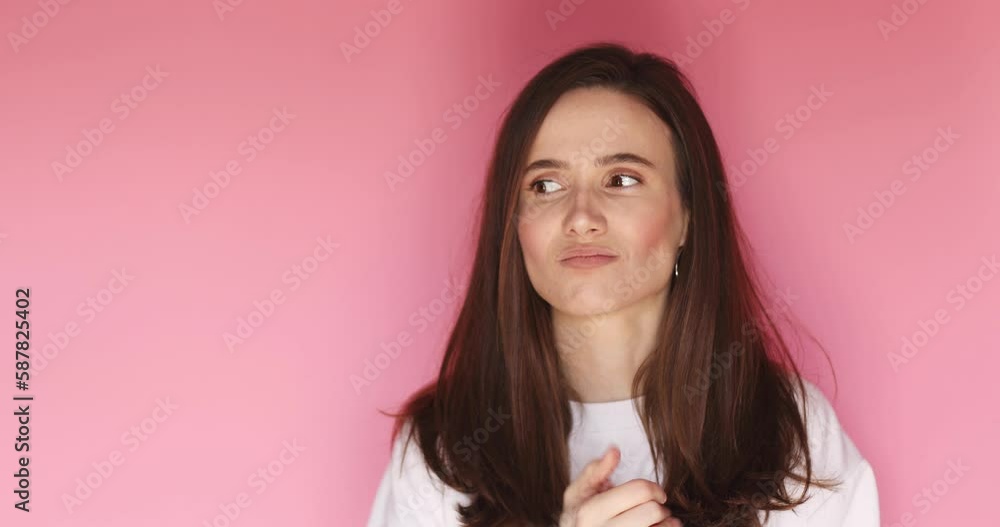 Portrait of nervous woman wringing hands, look by side, search solution of problem. Bed mood. Disappointed troubled confused young woman isolated on pink background. Portrait of nervous woman wringing hands, look by side, search solution of problem. Bed mood. Disappointed troubled confused young woman isolated on pink background.