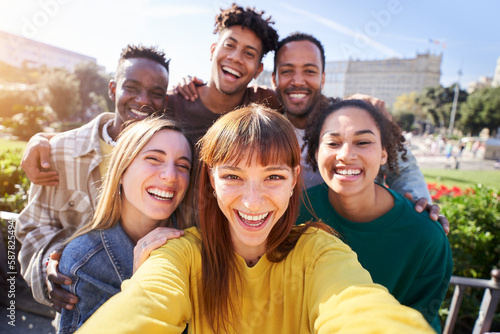 Group of happy friends posing for a selfie on a spring day as they party together outdoors. Group of multicultural friends having a good time together on the weekend. photo