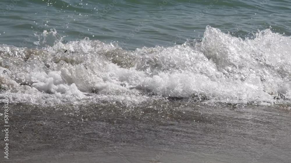 Clear sea surf waves wash sandy shore. Black Sea water foam on tides. Sea vacation beach resort, summertime seascape, environment protection of seas Clear sea surf waves wash sandy shore. Black Sea water foam on tides. Sea vacation beach resort, summertime seascape, environment protection of seas