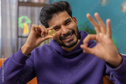 Quadro em tela Indian man freelancer holding gold coin successful developer programmer