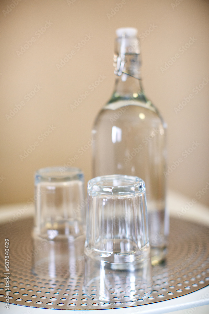 Two small drinking glasses and an empty water bottle Two small drinking glasses and an empty water bottle