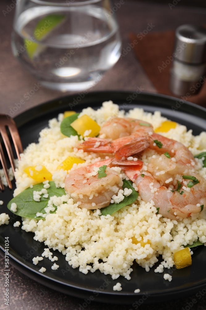 Tasty couscous with shrimps, bell pepper and basil on brown textured table Tasty couscous with shrimps, bell pepper and basil on brown textured table