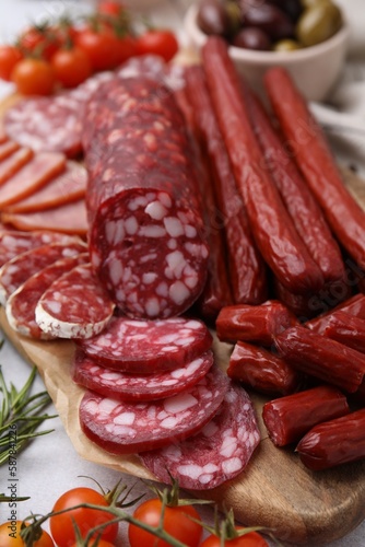 Different types of delicious sausages and ingredients on light grey table, closeup