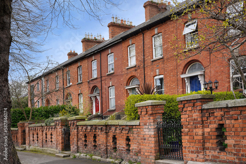 Row of traditional brick townhouses with brick walls protecting the front yard