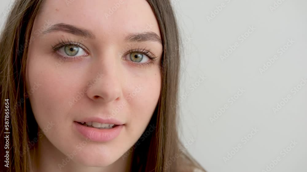 A close-up portrait of a young woman is a random portrait in a positive way, a big smile, a beautiful model posing in the studio on a white background. Caucasian portrait woman. A close-up portrait of a young woman is a random portrait in a positive way, a big smile, a beautiful model posing in the studio on a white background. Caucasian portrait woman.