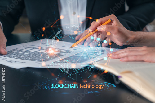 Businesspeople in formal wear taking notes signing contract at office workplace. Concept of important working moments, document sign, working process, concentration. Hands shot. Blockchain hologram