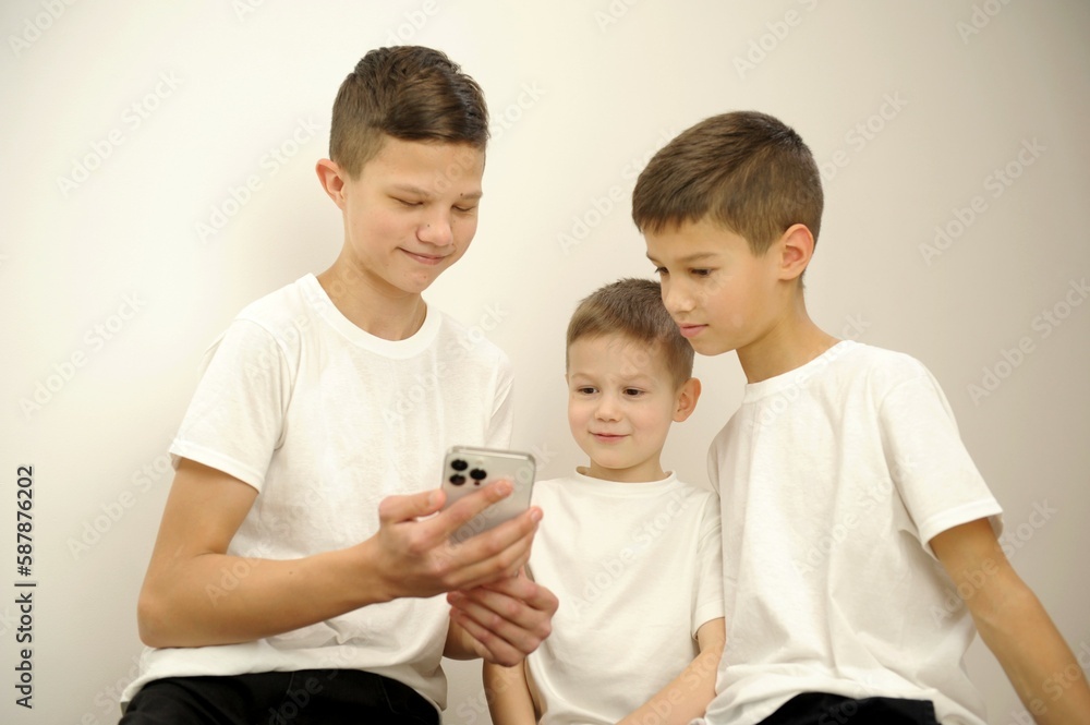 group of young friends with very excited expressions while using their smart phones while standing against an isolated background. High quality photo group of young friends with very excited expressions while using their smart phones while standing against an isolated background. High quality photo