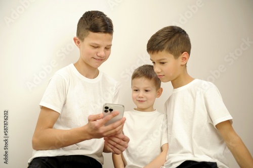 group of young friends with very excited expressions while using their smart phones while standing against an isolated background. High quality photo