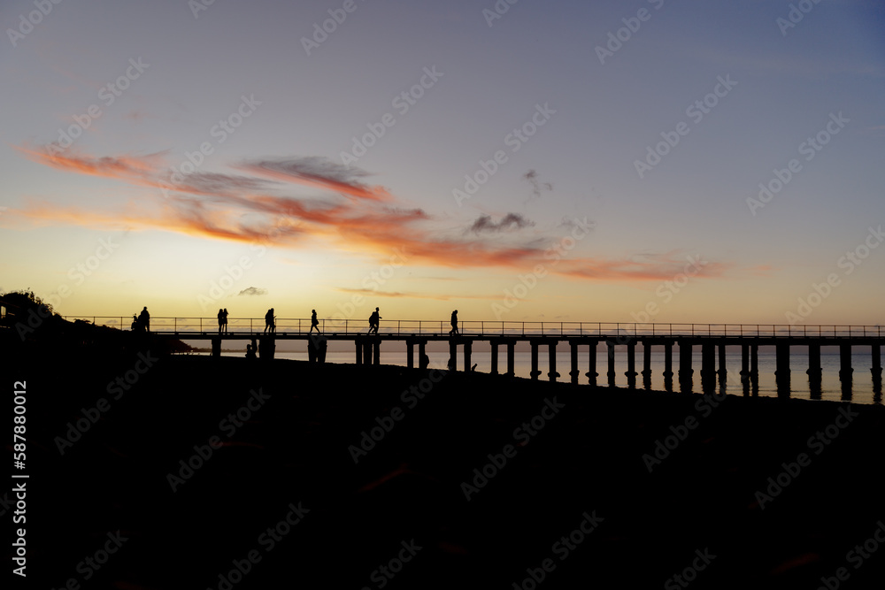 sunset over the pier at the beach sunset over the pier at the beach