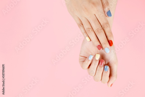 Beautiful female hand painting acrylic gel nails. Fashion style. Pink background.