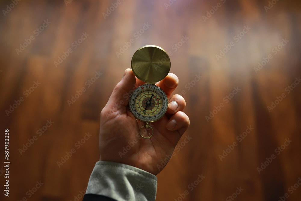man in suit holding golden compass on gray background man in suit holding golden compass on gray background