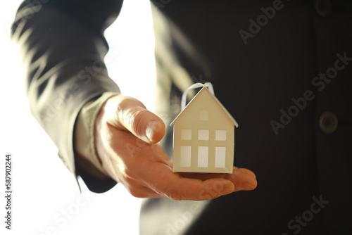 Real estate agent holding a toy house