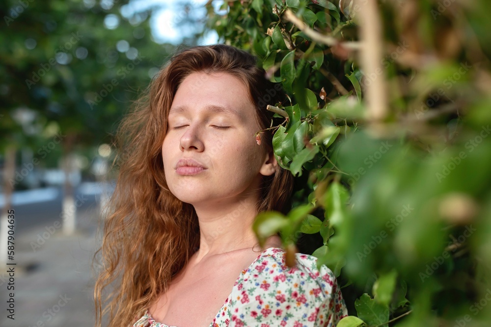 Portrait of beautiful young woman in dress is enjoy summer or spring day on natural green natural wall background in garden or forest on nature Portrait of beautiful young woman in dress is enjoy summer or spring day on natural green natural wall background in garden or forest on nature