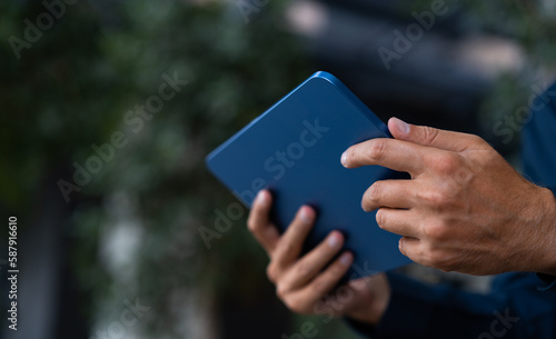 Man hands holding tablet outside