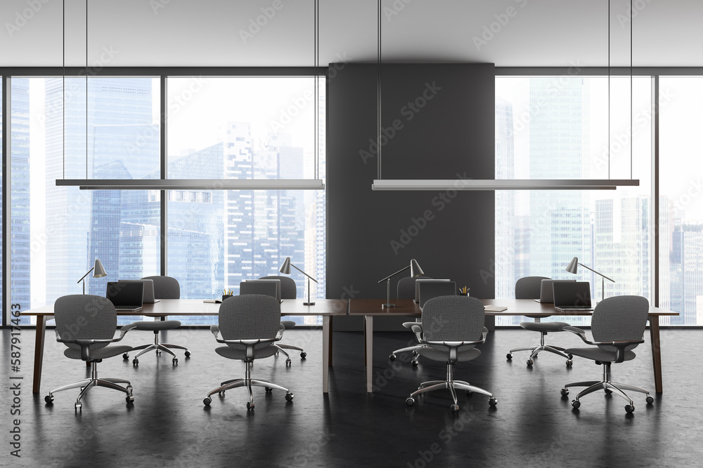 Grey business workplace interior with laptop on shared desk, panoramic window Grey business workplace interior with laptop on shared desk, panoramic window