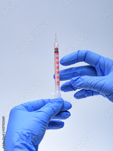 strzykawka trzymana w dłoniach przygotowywana do szczepienia pacjenta przez pielęgniarkę w przychodni