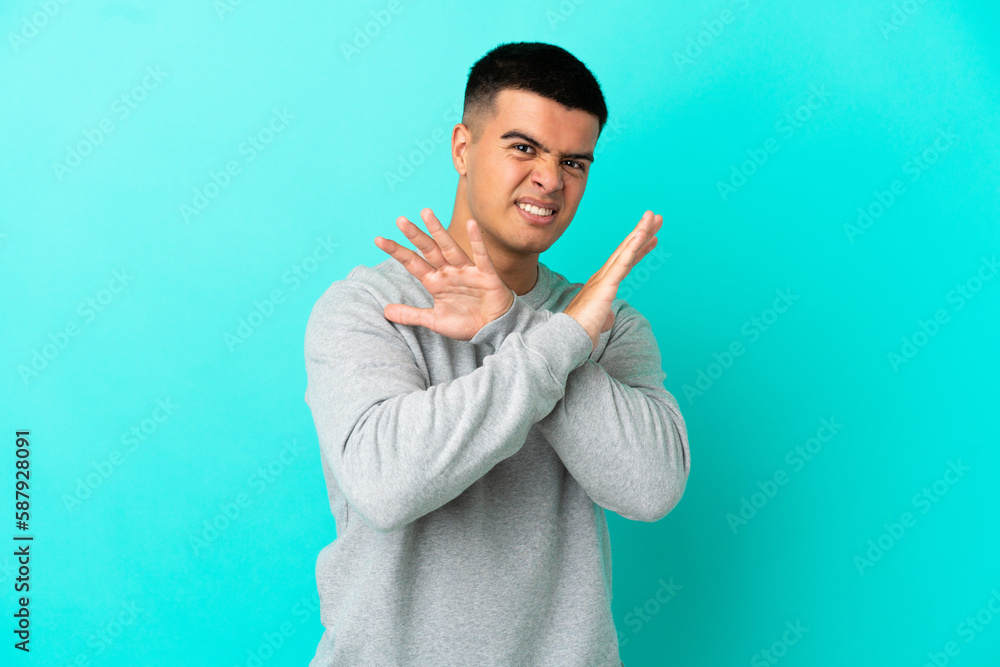 Young handsome man over isolated blue background nervous stretching hands to the front Young handsome man over isolated blue background nervous stretching hands to the front