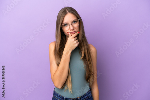 Young Lithuanian woman isolated on purple background having doubts