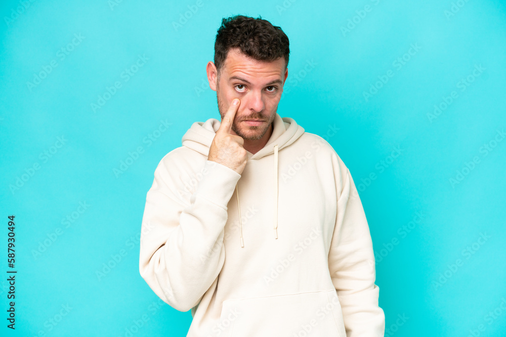 Young caucasian handsome man isolated on blue background showing something Young caucasian handsome man isolated on blue background showing something
