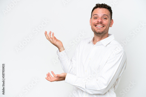 Young caucasian handsome man isolated on white background extending hands to the side for inviting to come