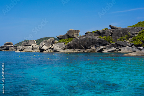 Tropical island of Andaman coast with turquoise and clear blue waters against blue sky.